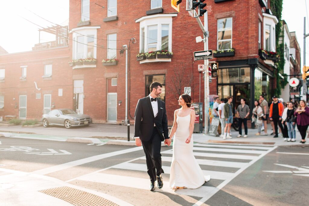Bride and groom walking down the street at sunset in Toronto